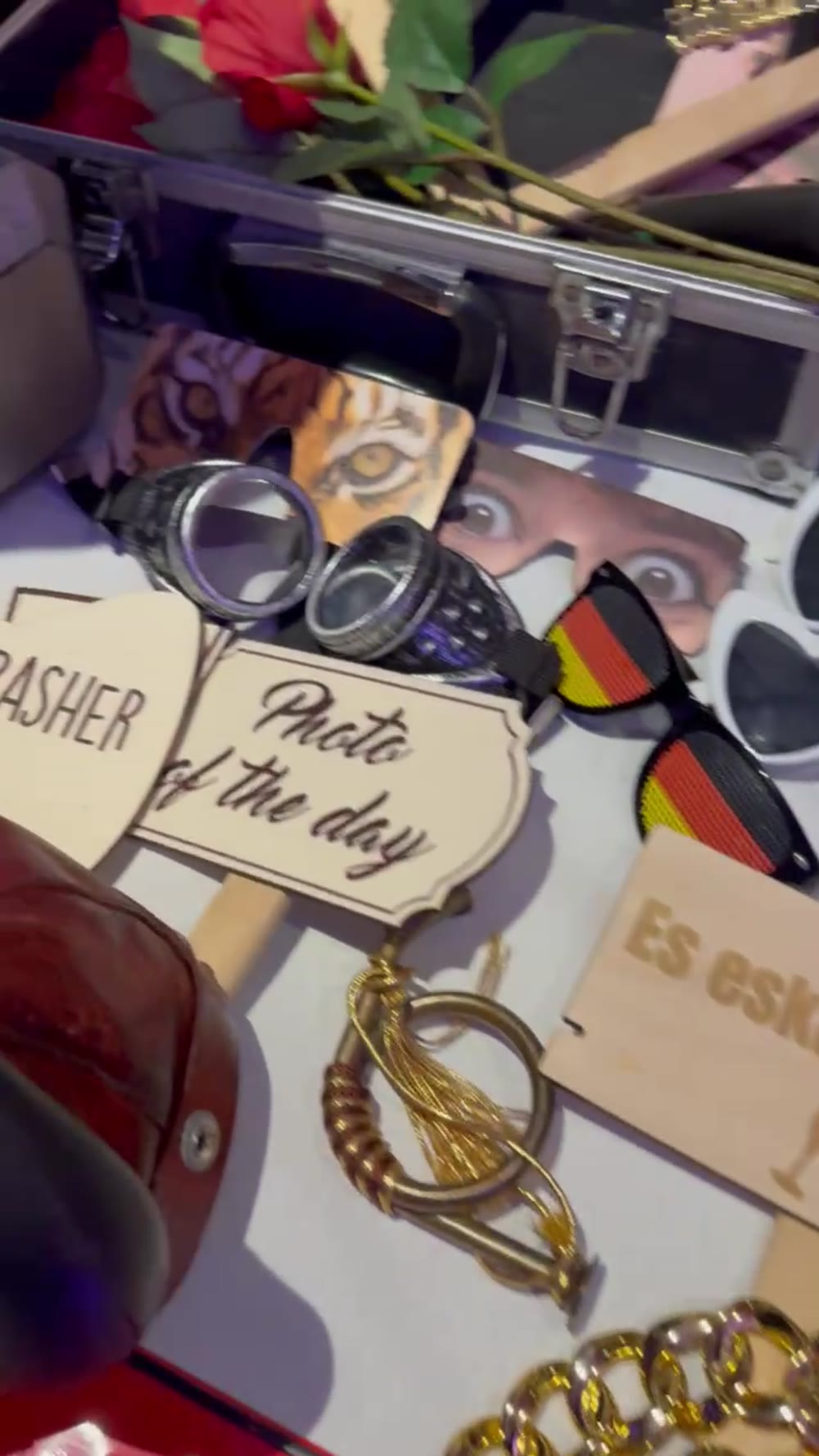 Open prop case with sunglasses, animal masks and wooden signs from the photo booth