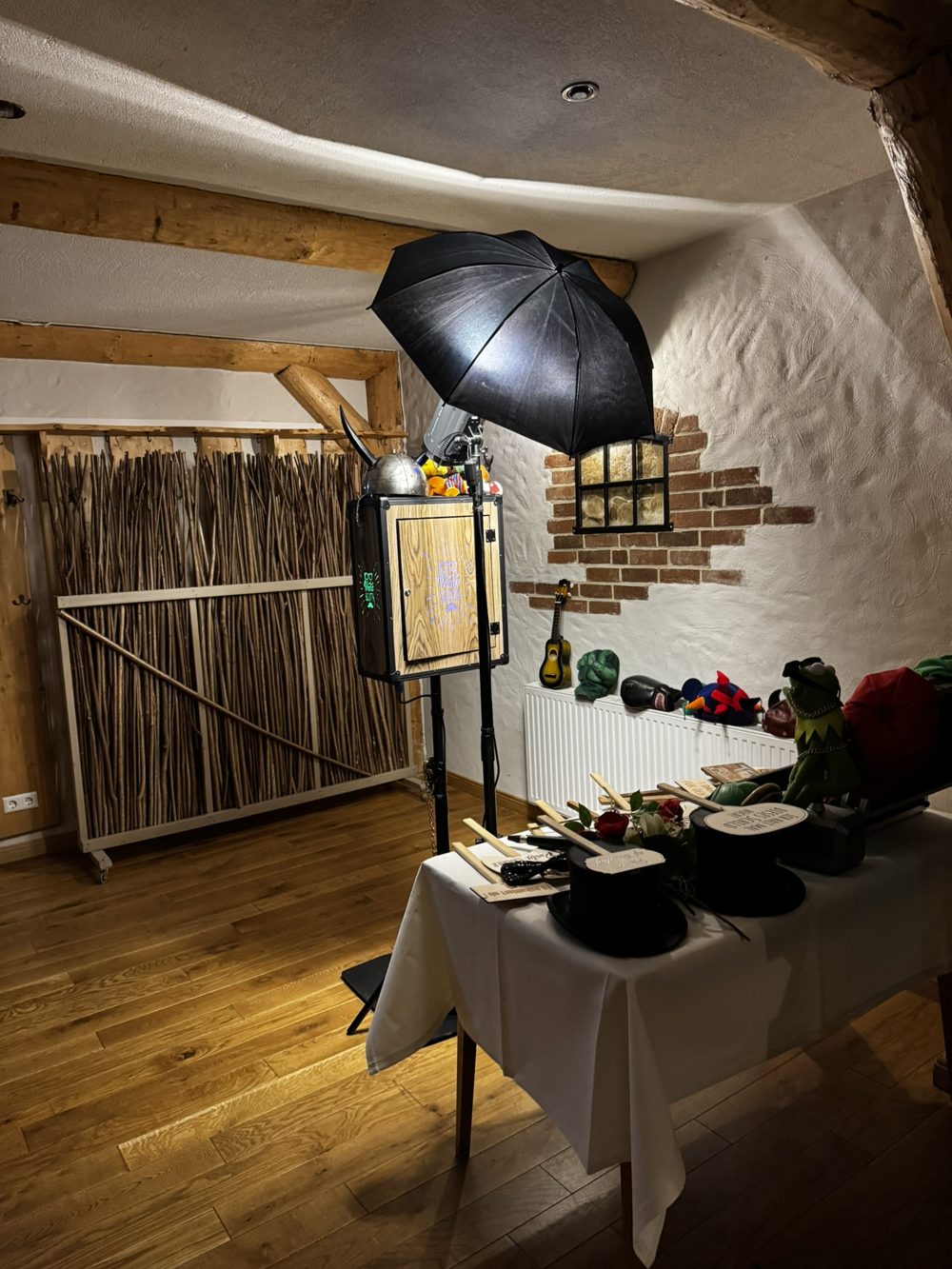 Fotobox-Ecke mit Reisigwand als Hintergrund und Backsteinfenster in der Köhlerdiele